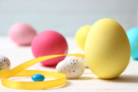 Easter composition of painted eggs and feathers on a colored background.の写真素材