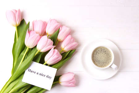 A bouquet of beautiful tulips and a card for text on a wooden backgroundの写真素材