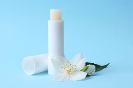lip balm and flowers on a colored background close-upの写真素材