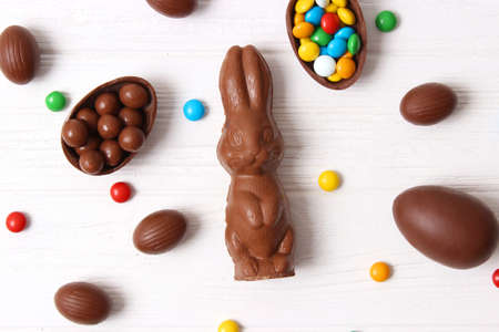 Easter composition with chocolate eggs and chocolate rabbit on wooden backgroundの写真素材