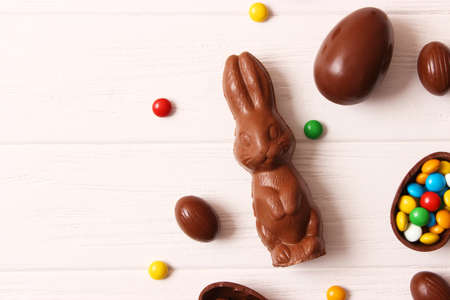 Easter composition with chocolate eggs and chocolate rabbit on wooden backgroundの写真素材
