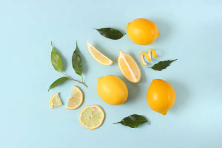 lemons and green leaves on a colored background.の写真素材