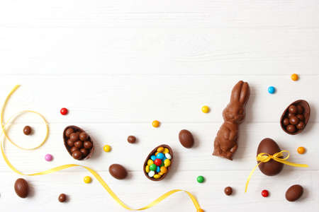 Easter composition with chocolate eggs and chocolate rabbit on wooden backgroundの写真素材