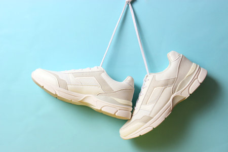 Modern trendy sneakers hang on laces on a colored background.の写真素材