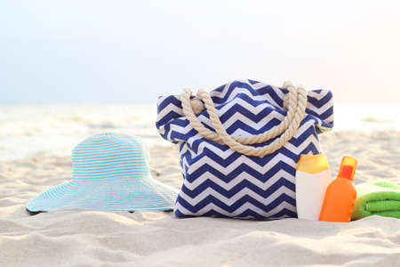 beach accessories and sunscreens on the sand of the seasideの写真素材