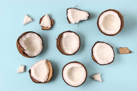 broken coconut on a colored background top view.