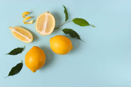 lemons and green leaves on a colored background.の写真素材