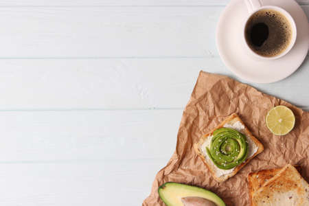 Toasted toast with avocado on a wooden table.の写真素材