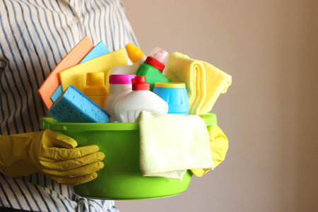 Housewife holds a basket with cleaning and disinfection productsの写真素材