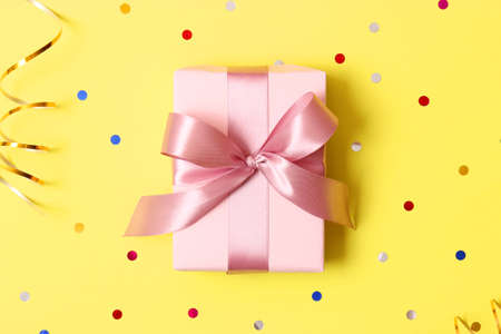 gift and sparkles of confetti on a colored background top view. minimalismの写真素材