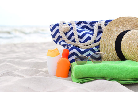 beach accessories and sunscreens on the sand of the seaside