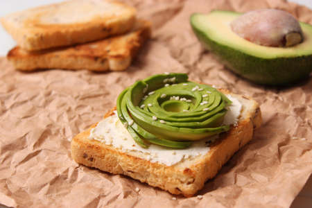 Toasted toast with avocado on a wooden table.