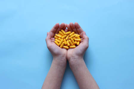 Medical pills in the hands of a child close-up.