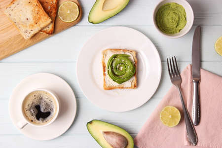 Toasted toast with avocado on a wooden table.の写真素材