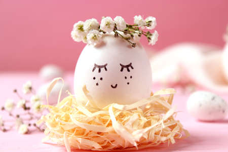 Easter composition of painted eggs and feathers on a colored background.
