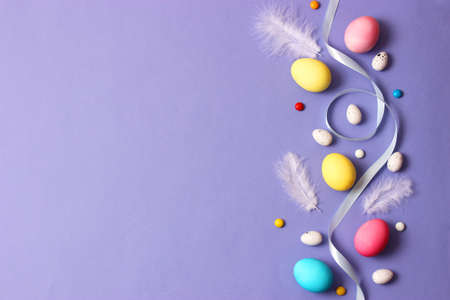 Easter composition of painted eggs and feathers on a colored background.の写真素材