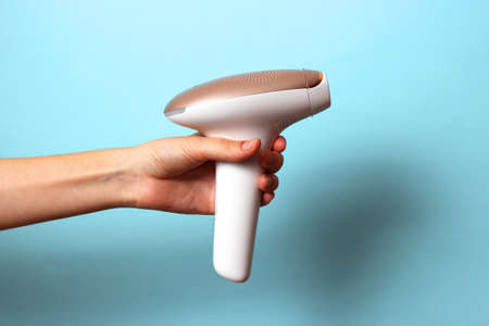 Modern home photoepilator in female hands. Remove unwanted hair.の写真素材
