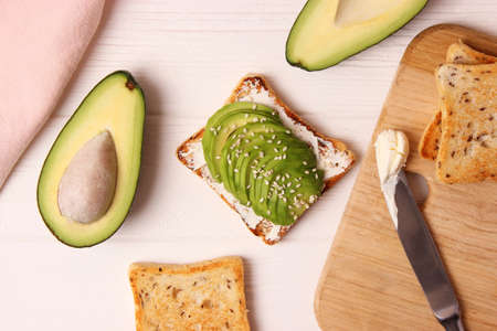Toasted toast with avocado on a wooden table.の写真素材