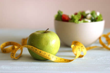 tape and lettuce on a light background. Slimming, diet, healthy food.