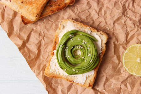 Toasted toast with avocado on a wooden table.