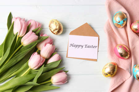 Easter composition of painted eggs and feathers on a colored background.