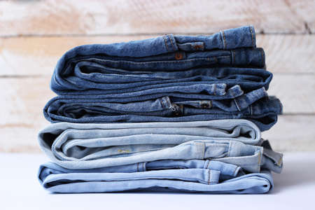 Stack of folded jeans on the tableの写真素材