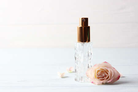 Perfume bottle and rose flowers on a light background close upの写真素材