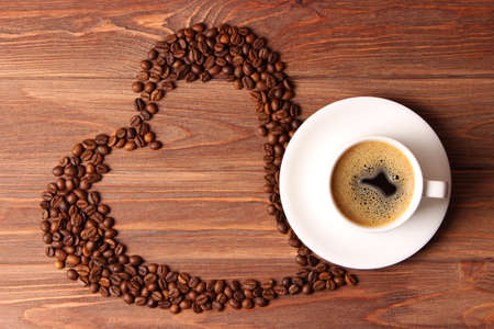 Cup of aromatic coffee and coffee beans on a wooden background.の写真素材