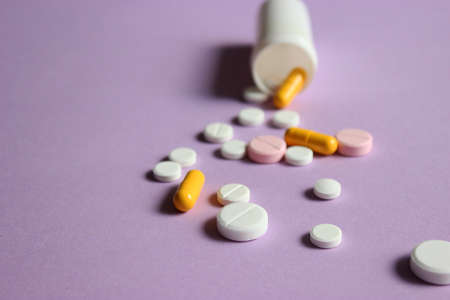 Pills on a colored background top view close-up. Medicines, vitamins
