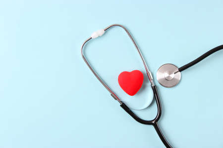 Stethoscope and heart on wooden color background. Health, medicine