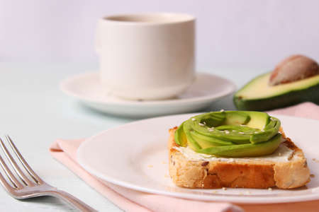 Toasted toast with avocado on a wooden table.の写真素材