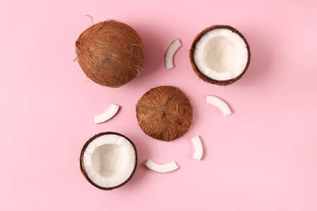broken coconut on a colored background top view.