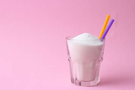 Refined sugar in a glass on a colored background. Diabetes concept, excess sugarの写真素材