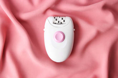 Modern mechanical epilator on a colored background close-up.の写真素材