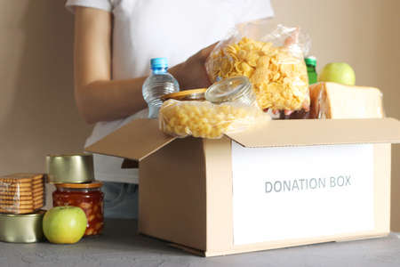 girl puts in a box with donations items. Volunteering