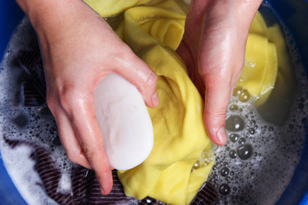 A woman washes clothes with her hands in soapy water. Hand wash clothes.の写真素材