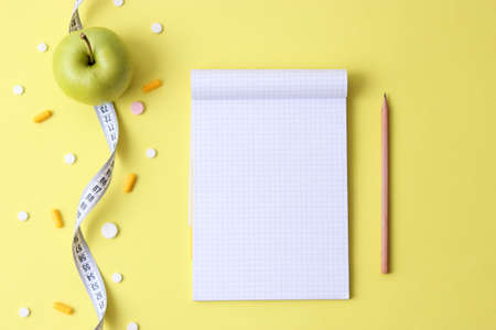 apple and measuring tape on a colored background close-up with place for text.