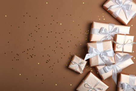 Gifts in gold packaging on a colored background with place for text.の写真素材
