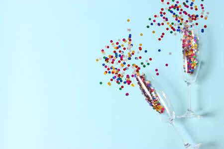 glasses and confetti on a colored background top view.の写真素材