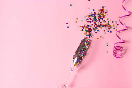 glasses and confetti on a colored background top view.の写真素材