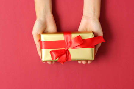 gift in female hands on a colored background top view.の写真素材