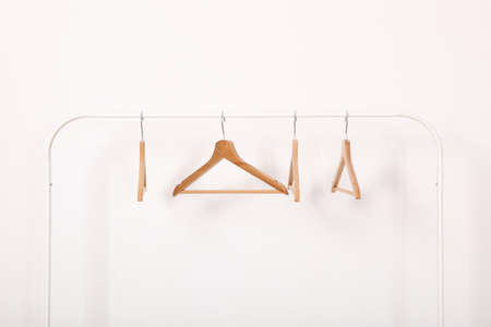 empty clothes hangers on a wardrobe rack on a colored background.の写真素材