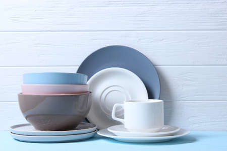 A set of dishes and kitchen utensils on a colored background.