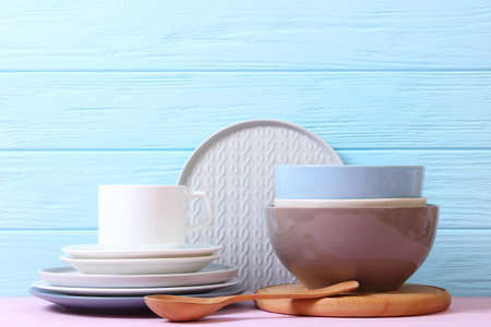 A set of dishes and kitchen utensils on a colored background.
