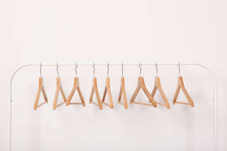empty clothes hangers on a wardrobe rack on a colored background.の写真素材