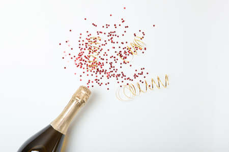 Champagne bottle, glasses and confetti on a colored background top view.の写真素材