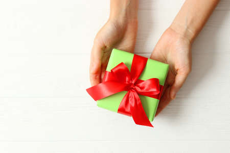 gift in female hands on a colored background top view.の写真素材