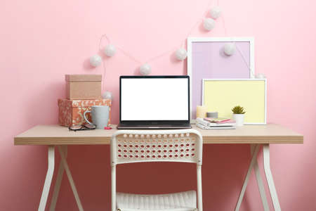 Workplace near the wall with a modern laptop.の写真素材