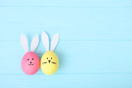 Easter eggs with cute faces and ears on a colored background.の写真素材