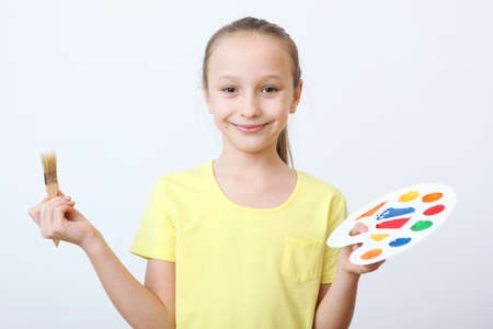 Cute little girl draws paints at home.の写真素材